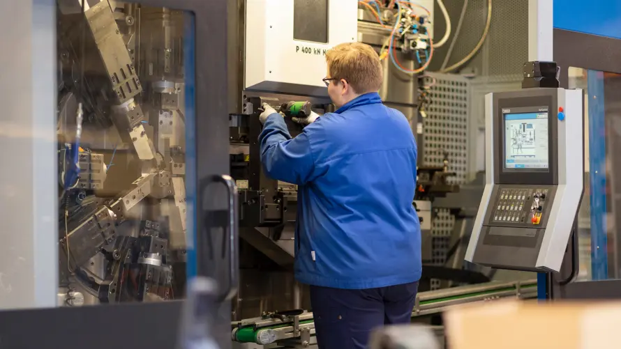 Employee adjusting a stamping press