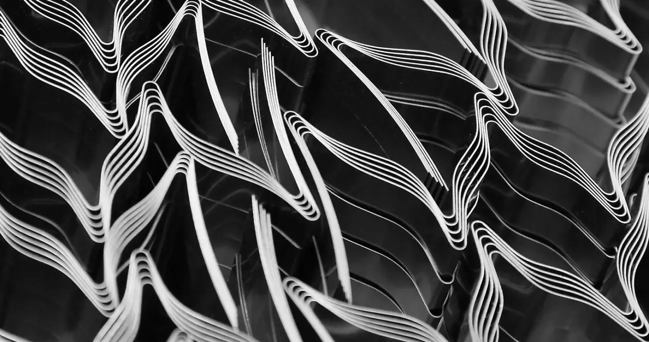Close-up of stacked metal parts bent into a repeating shape.