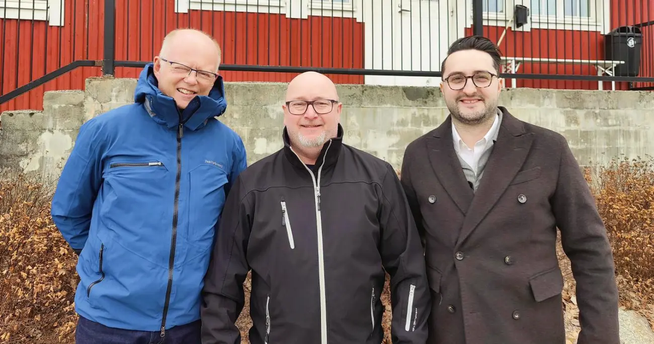 Gruppenfoto von drei Teammitgliedern von Meconet AB vor einem roten Gebäude.