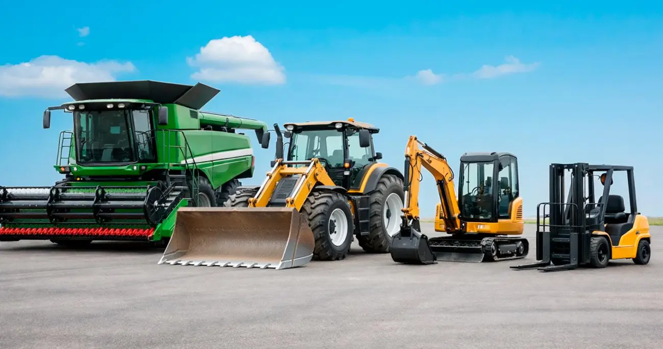Ein Mähdrescher, ein Traktor mit Frontlader, ein Minibagger und ein Gabelstapler nebeneinander.