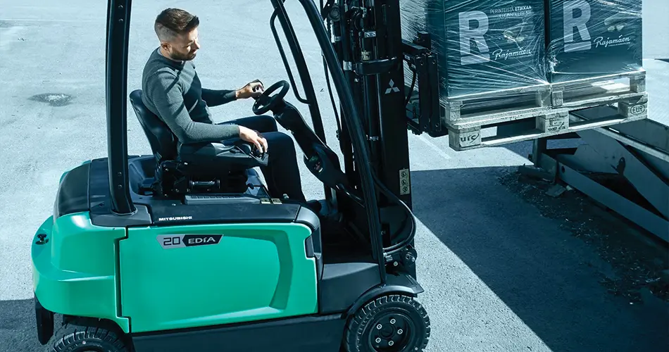 Ein Fahrer bewegt eine beladene Palette mit einem grünen Logisnext-Gabelstapler.