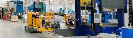 Produktionshalle im Werk Äänekoski mit einer großen Tiefziehpresse und einer Hubarbeitsbühne.