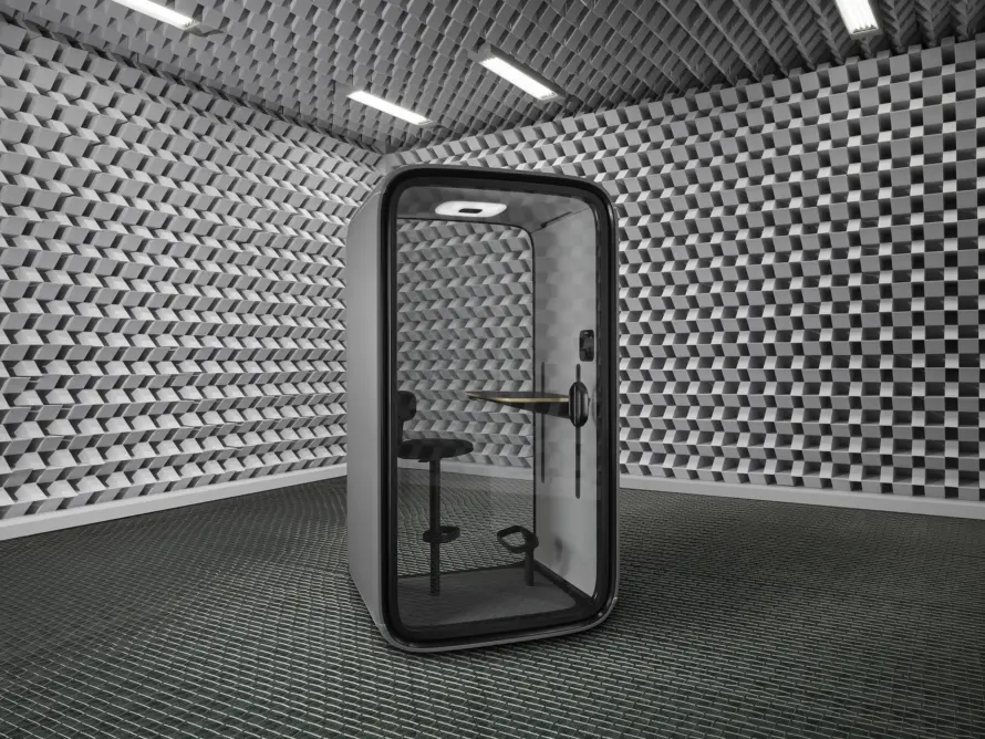 A Framery One pod in an acoustic test room with sound-absorbing wedges covering the walls and ceiling.